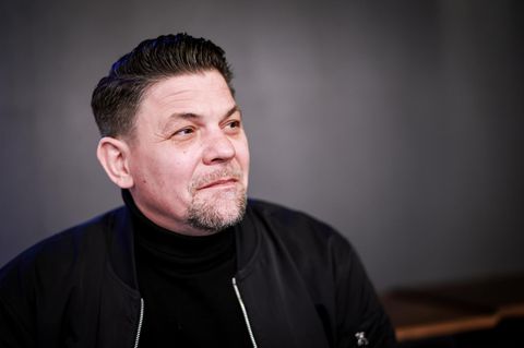 Tim Mälzer, ein Mann mit dunklen Haaren und Bart, schaut in die Ferne