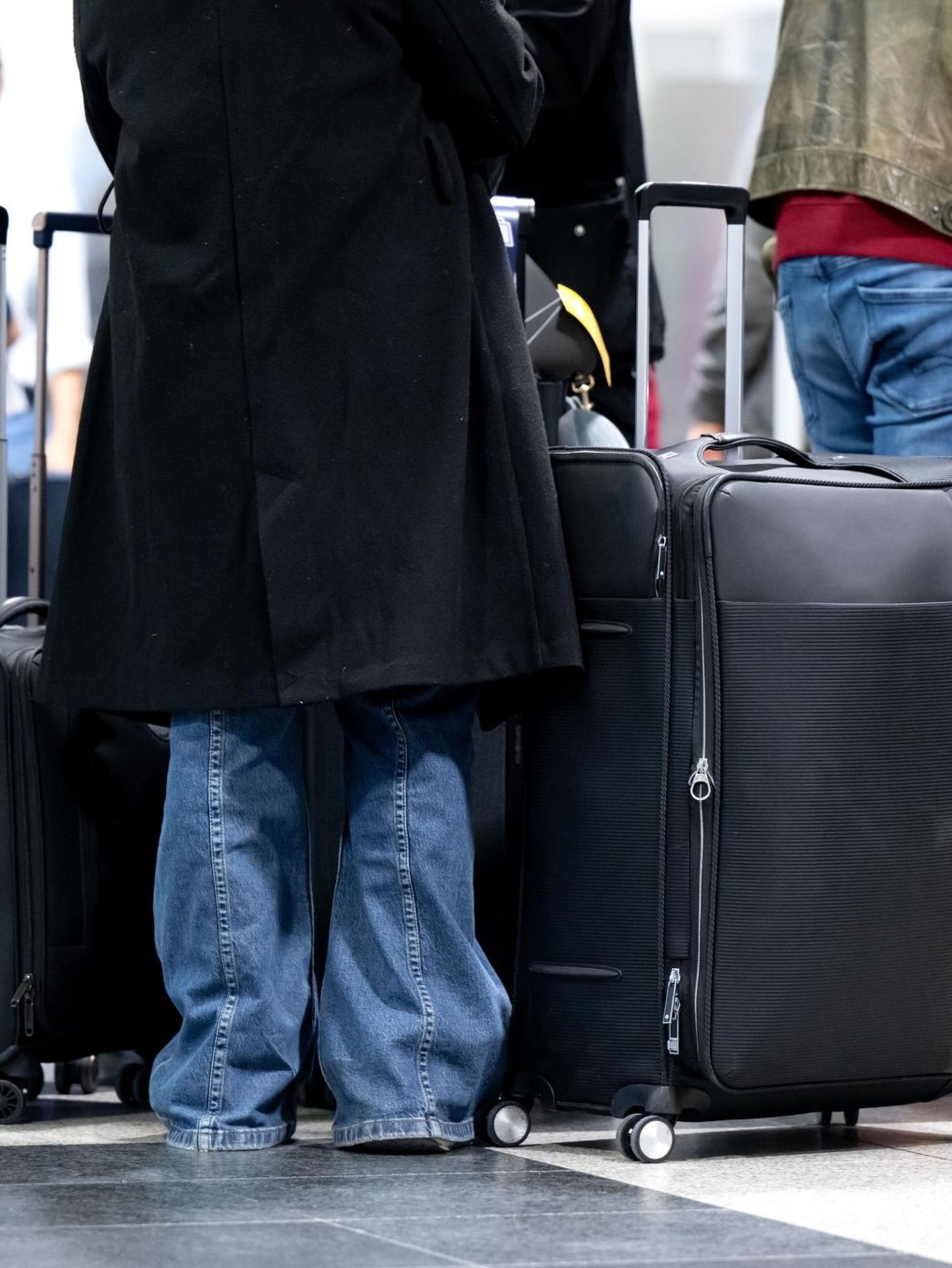 Passagiere warten am Flughafen München trotz Warnstreik auf ihren Flug