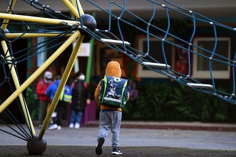 Kind geht über den Spielplatz einer Schule