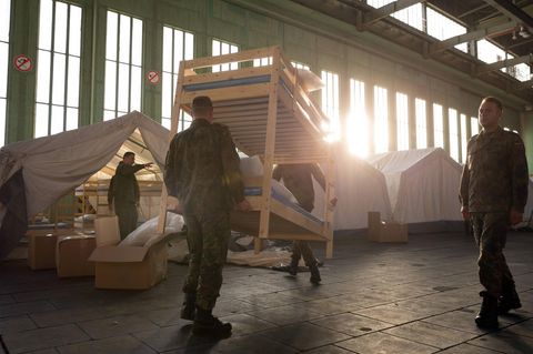 Zwei Soldaten tragen ein Stockbett durch den ehemaligen Flughafen in Berlin (Symbolbild Erstaufnahme)