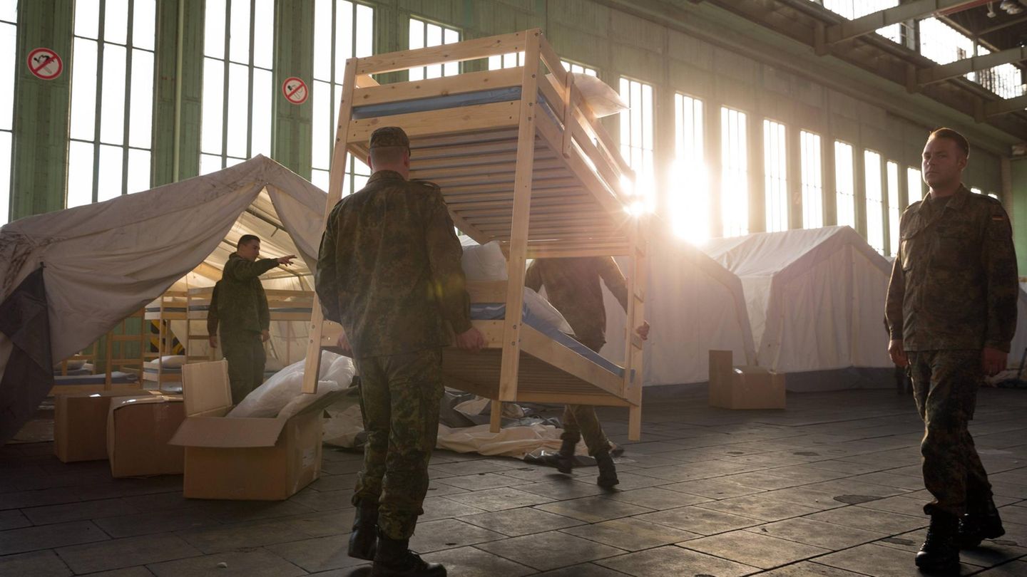 Zwei Soldaten tragen ein Stockbett durch den ehemaligen Flughafen in Berlin (Symbolbild Erstaufnahme)