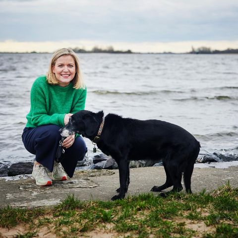 Hündin Lyra Die Autorin kniet neben ihrem Hund Lyra am Ufer der Elbe
