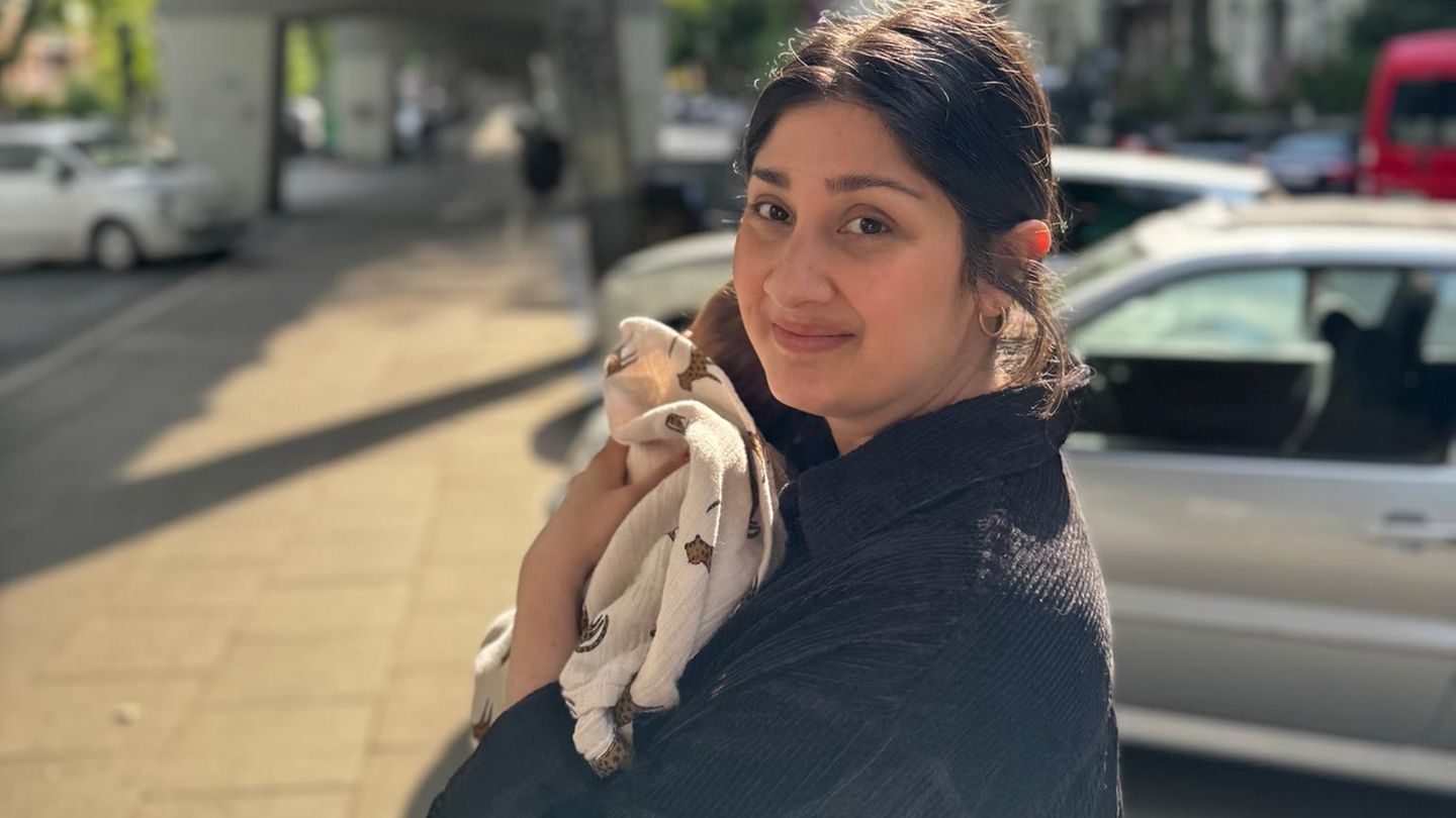 Anahita G. hält ihre Tochter auf dem Arm.