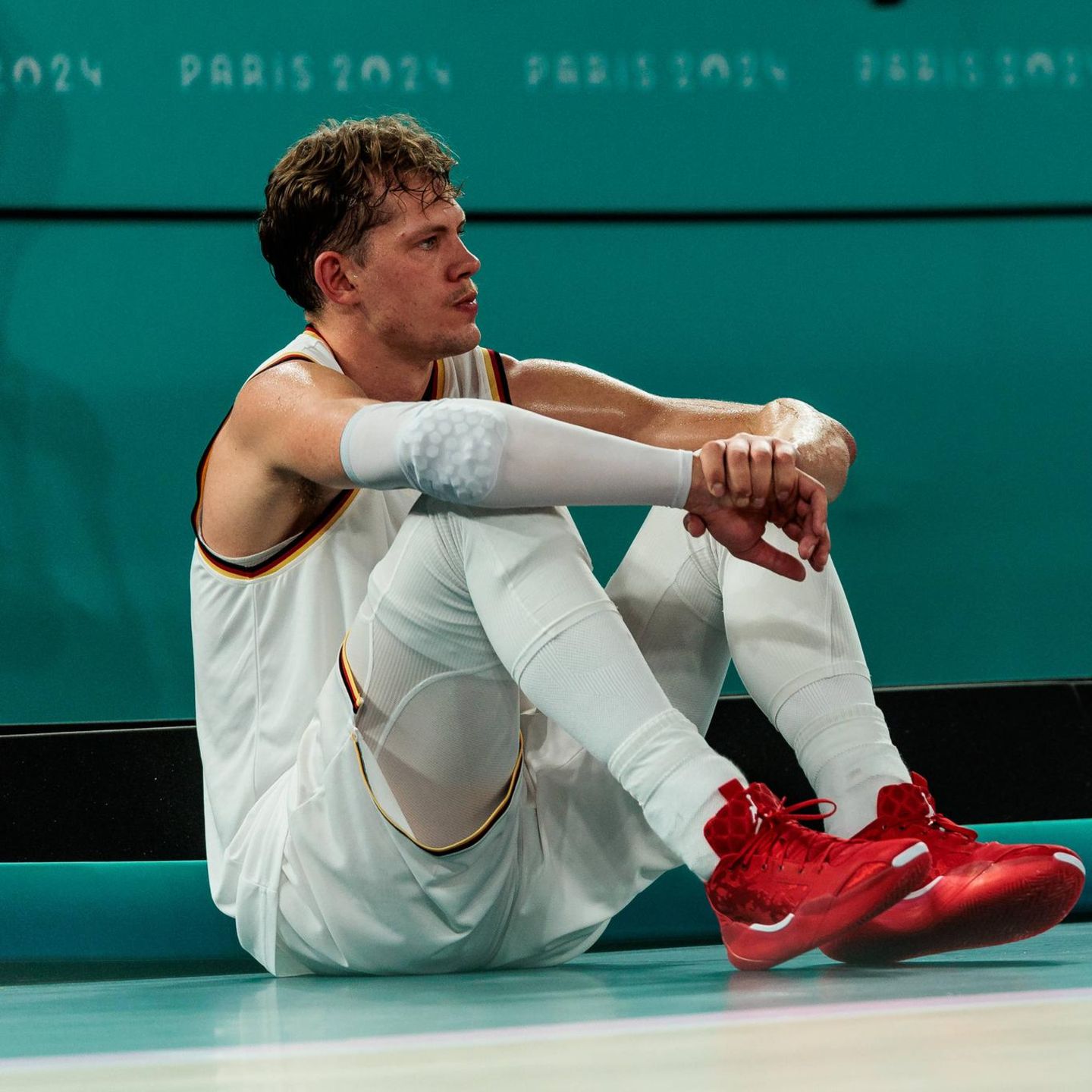 Moritz Wagner sitzt nach dem verlorenen Halbfinale bei Olympia in Paris auf dem Boden