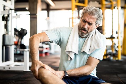 Muskelkater: Mann hält sich beim Sport das Bein