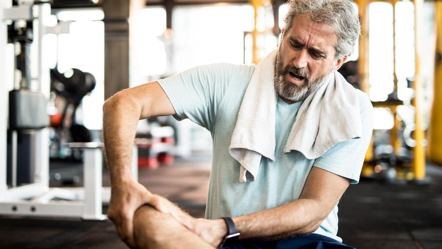 Muskelkater: Mann hält sich beim Sport das Bein