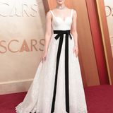 Elle Fanning in einer weißen Robe mit schwarzem Band bei den Oscars