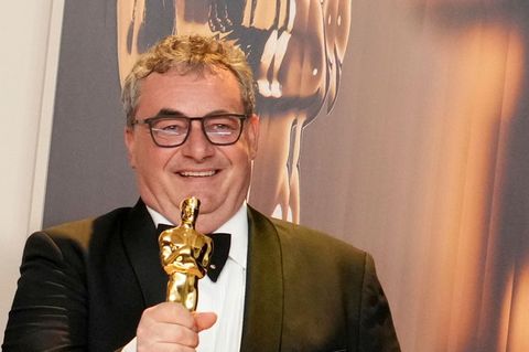 Special-Effects-Experte Gerd Nefzer lächelt mit einem Oscar in der rechten Hand