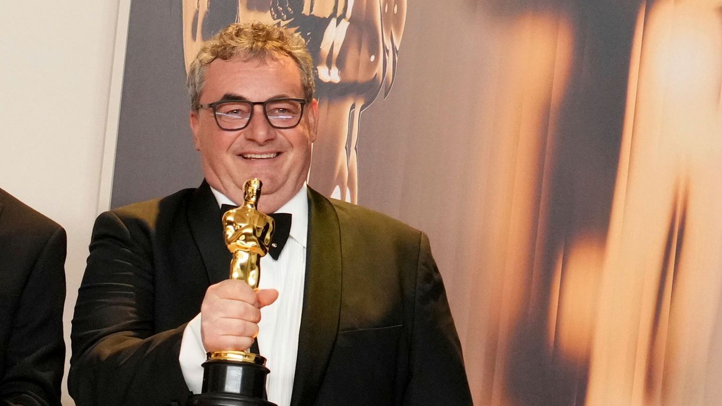 Special-Effects-Experte Gerd Nefzer lächelt mit einem Oscar in der rechten Hand