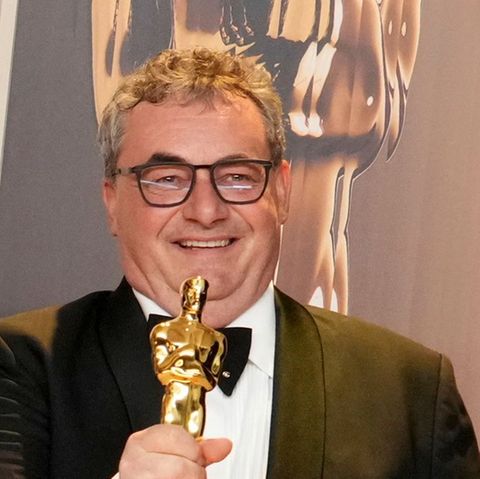 Special-Effects-Experte Gerd Nefzer lächelt mit einem Oscar in der rechten Hand