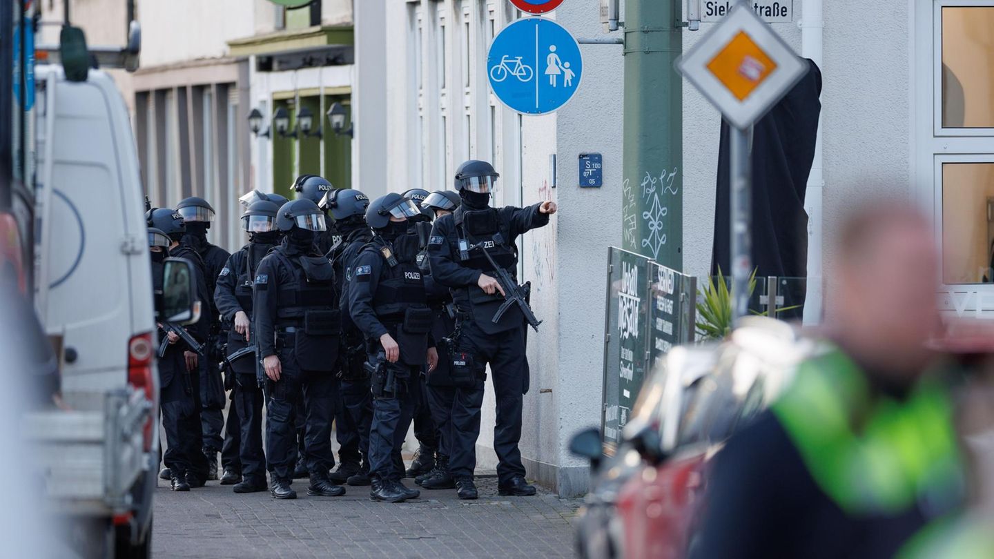 Ein schwer bewaffneter Polizei-Trupp steht am Landgericht Bielefeld auf dem Fußweg