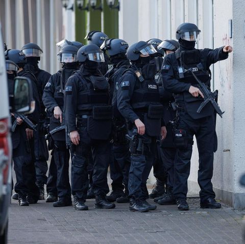Ein schwer bewaffneter Polizei-Trupp steht am Landgericht Bielefeld auf dem Fußweg