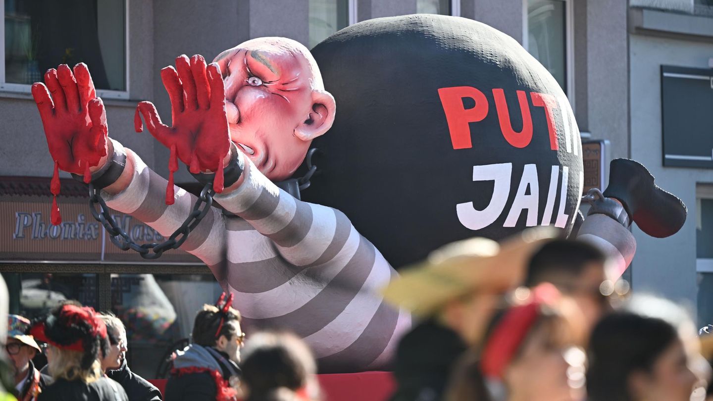 Ein Motivwagen in Düsseldorf zeigt Putin mit blutigen Händen auf dem Boden liegend, wie er von einer Fußfessel zerquetscht wird