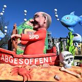 Mottowagen in Düsseldorf: Olaf Scholz in einem Wrack mit einem Totenkopf mit Schriftzug "Lindner"