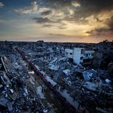 Menschen versammeln sich bei Sonnenuntergang inmitten der Trümmer um eine lange Tafel