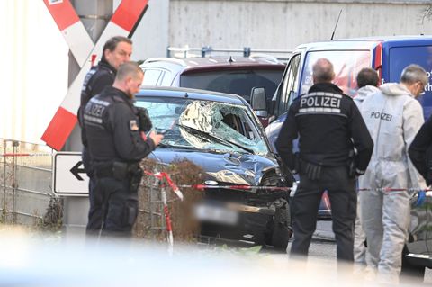 Mannheim: Einsatzkräfte der Polizei stehen bei einem Großeinsatz neben dem beschädigten Fahrzeug in der Innenstadt