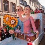 Motivwagen in Köln: Alice Weidel und Sahrah Wagenknecht halten drei Blumen mit Putins Gesicht