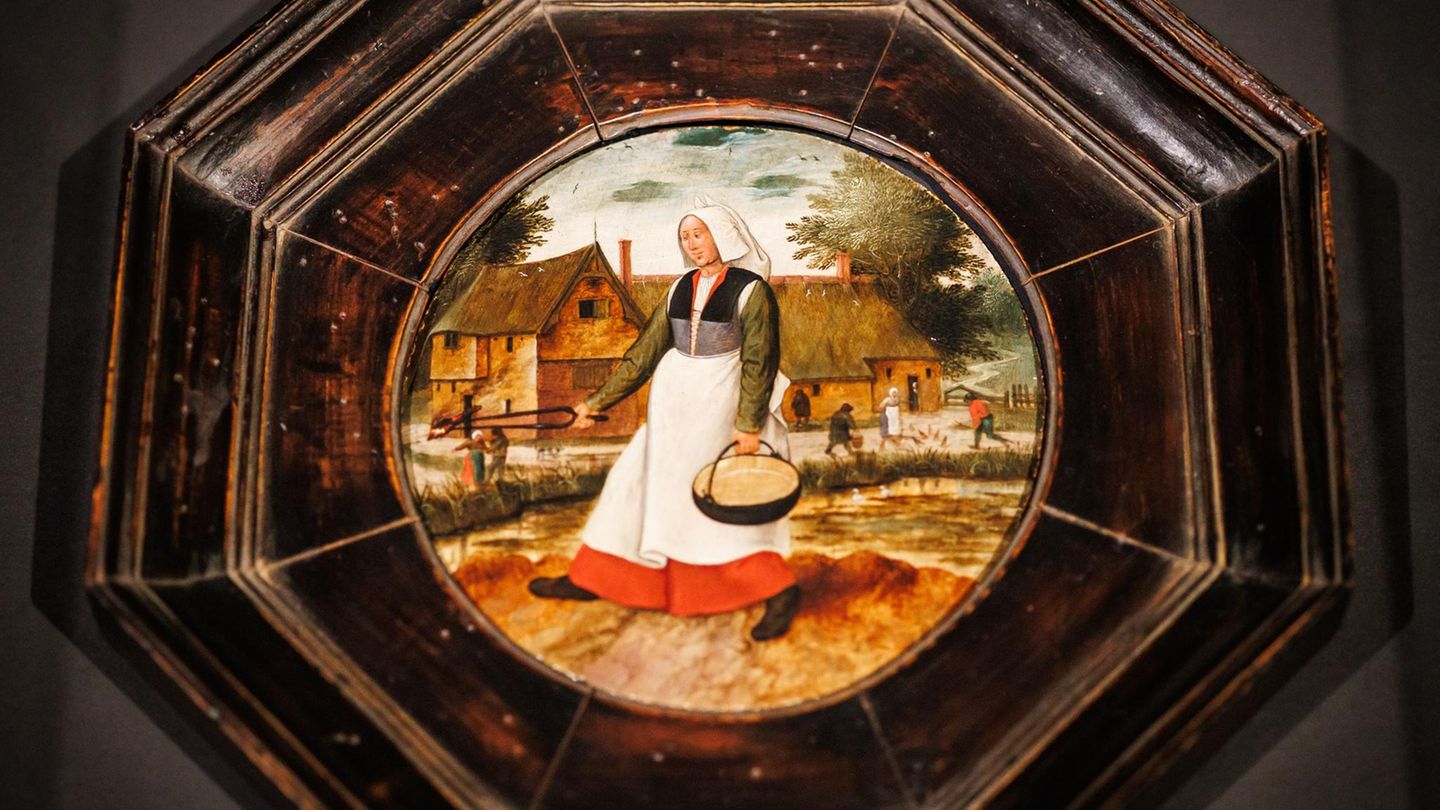 Eine Bäuerin, die einen Eimer mit Wasser hält, zeigt das Gemälde, das vor etwa 50 Jahren in Polen gestohlen wurde