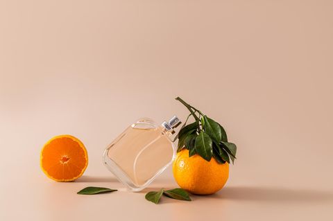 Parfüm steht neben Mandarinen