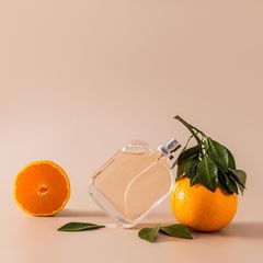 Parfüm steht neben Mandarinen