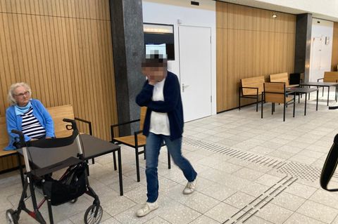 Die Angeklagte (r.) geht im Gerichtsflur in Lübeck an ihrer ehemaligen Chefin (l.) vorbei, ohne sie anzusehen