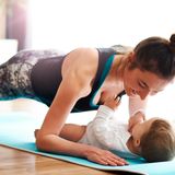 Fitness: Mama macht Planks mit Baby auf der Matte