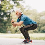Fitness: Älterer Mann macht Squats im Park