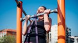 Fitness: Frau trainert Klimmzüge im Freien