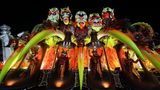 Karneval in Rio de Janeiro: Karnevalswagen mit fünf großen bunten Köpfen, die aussehen wie Masken mit Grimassen