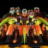 Karneval in Rio de Janeiro: Karnevalswagen mit fünf großen bunten Köpfen, die aussehen wie Masken mit Grimassen