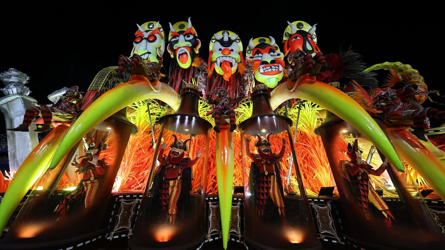 Karneval in Rio de Janeiro: Karnevalswagen mit fünf großen bunten Köpfen, die aussehen wie Masken mit Grimassen