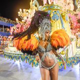 Karneval in Rio de Janeiro: Frau in bunten, glitzernden Feder-Kostüm vor Karnevalswagen beim Tanzen