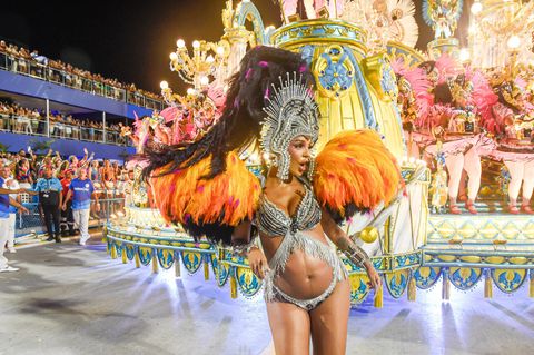 Karneval in Rio de Janeiro: Frau in bunten, glitzernden Feder-Kostüm vor Karnevalswagen beim Tanzen