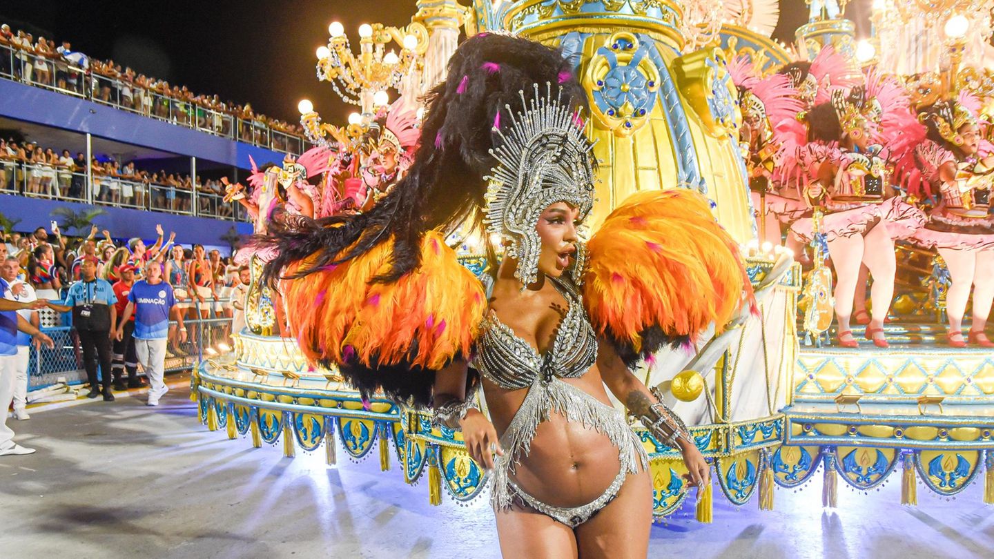 Karneval in Rio de Janeiro: Frau in bunten, glitzernden Feder-Kostüm vor Karnevalswagen beim Tanzen