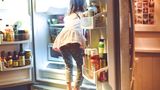 Keime: Mädchen schaut in den Kühlschrank