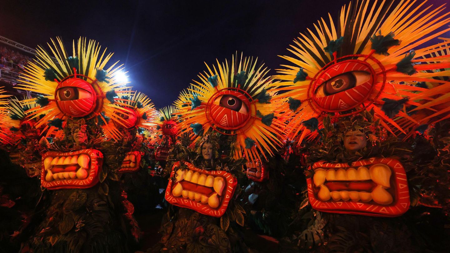 Karneval in Rio de Janeiro: Tänzerinnen in auffälligen Kostümen mit einem großen Auge und Federn als Kopfschmuck