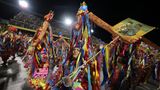 Karneval in Rio de Janeiro: Tänzerinnen in bunten Kostümen paradieren über die Straße