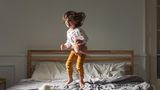 Keime: Kleinkind springt auf dem Bett