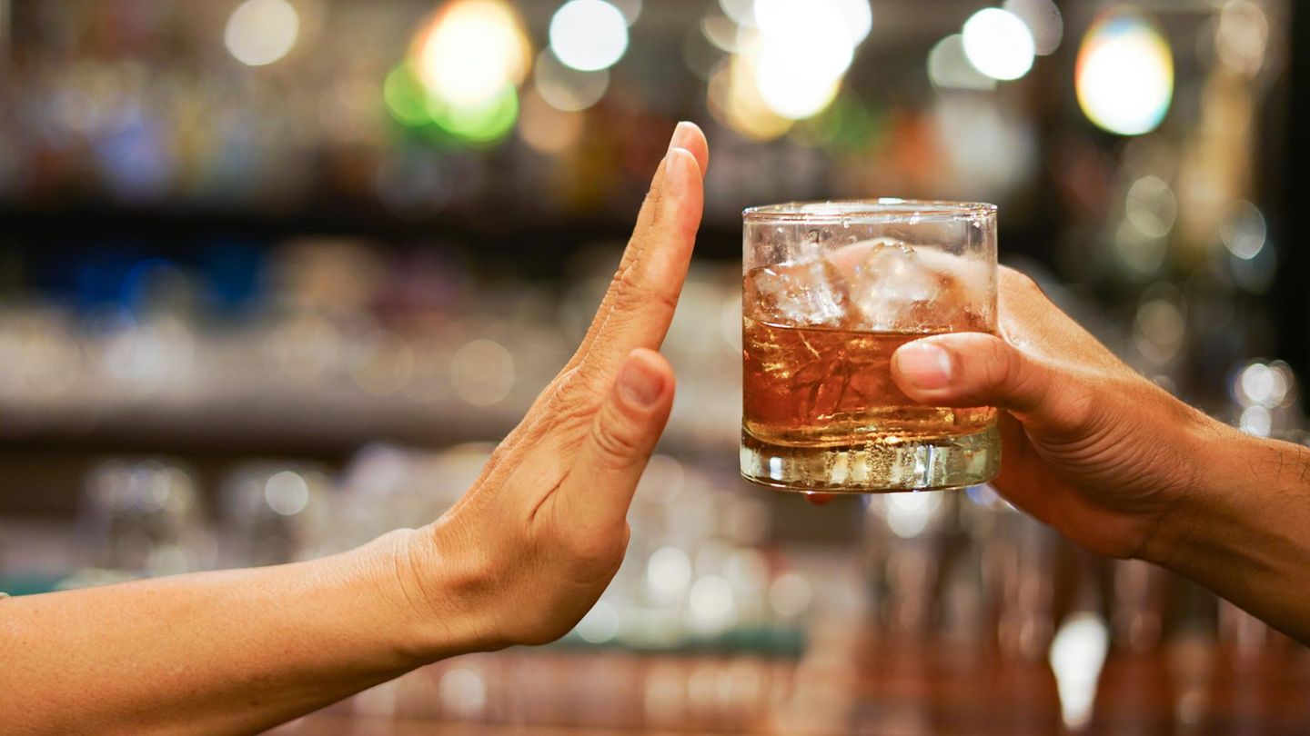 Eine Hand macht eine abwehrende Bewegung zu einem angebotenen Glas Alkohol – Fastenzeit