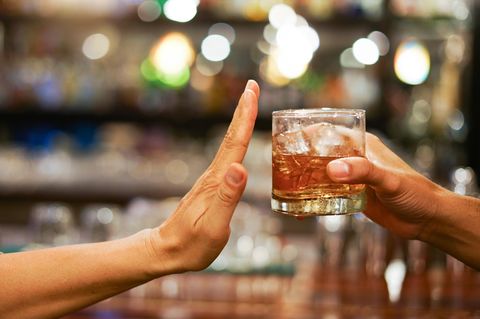 Eine Hand macht eine abwehrende Bewegung zu einem angebotenen Glas Alkohol – Fastenzeit