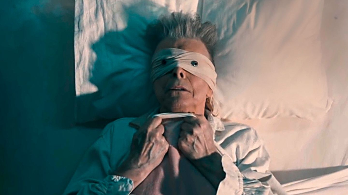 David Bowie mit verbundenen Augen in seinem Musikvideo zu "Lazarus"