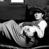 David Bowie liegt in einem Sessel und hat ein Schwein auf dem Schoß