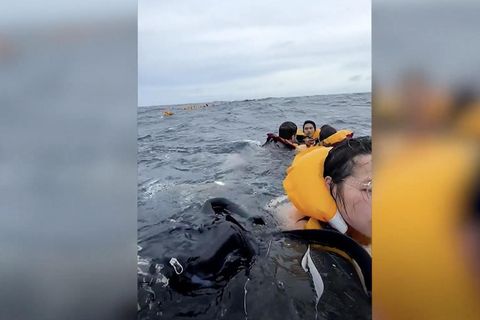 Touristen sind in gelben Rettungswesten im offenen Meer gestrandet