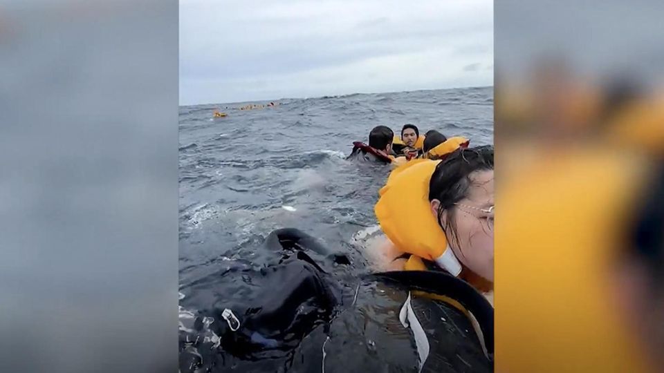 Touristen sind in gelben Rettungswesten im offenen Meer gestrandet