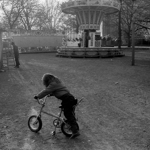 Ein einsames Kind fährt auf einem leeren Rummelplatz Fahrrad