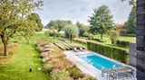 Garten längliches Schwimmbecken daneben zahlreiche Stauden