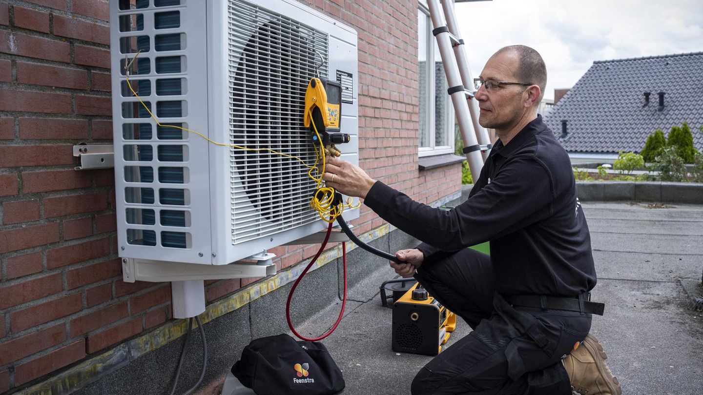 Ein Handwerker installiert eine Wärmepumpe