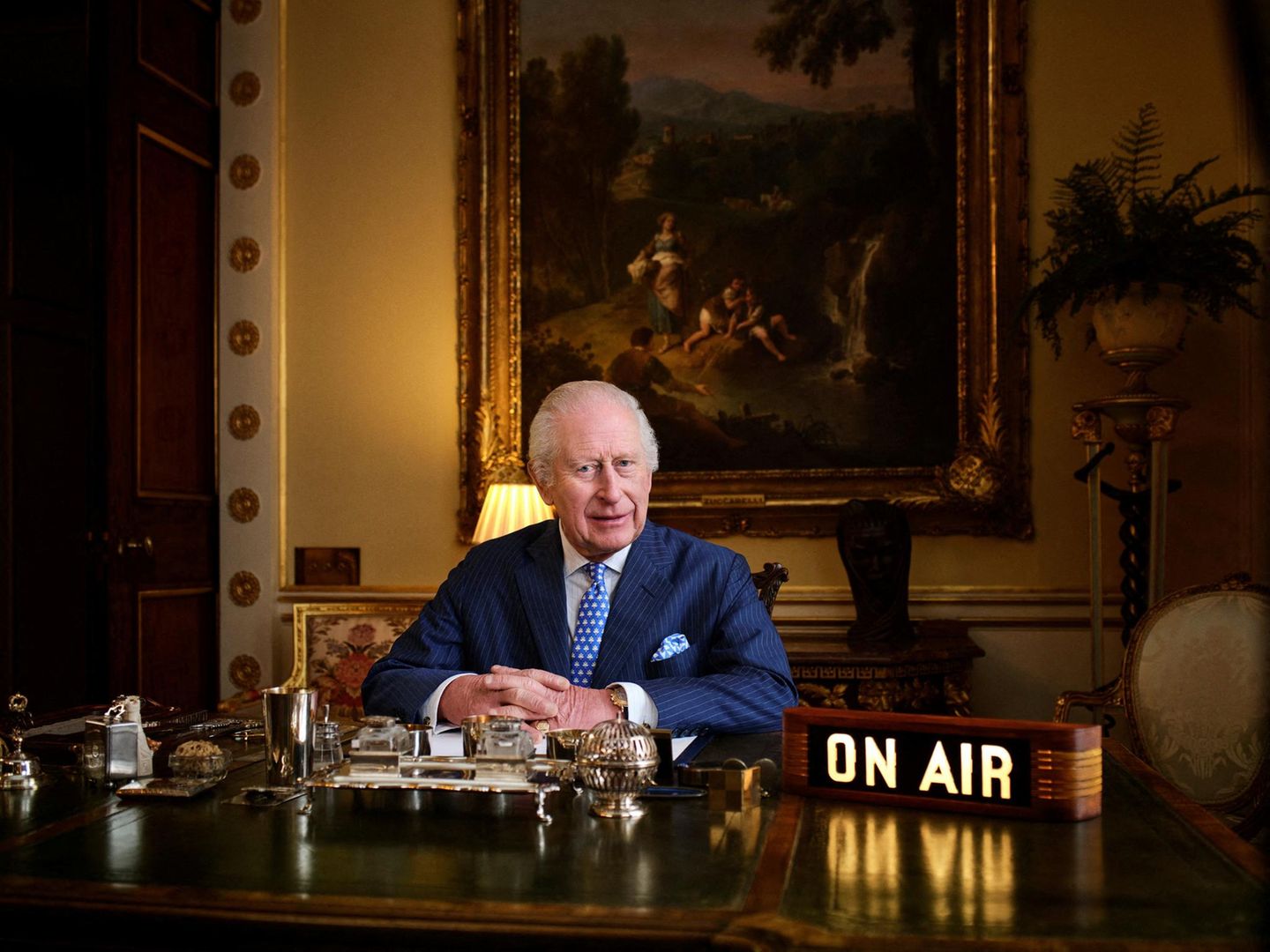 König Charles sitzt am Tisch