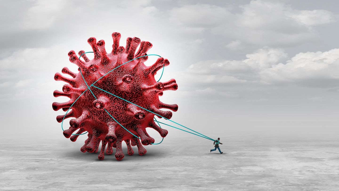 Ein Mann läuft und zieht an Schnüren ein riesiges Virus hinter sich her Ein Mann läuft und zieht an Schnüren ein riesiges Virus hinter sich her
