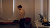 Lennart steht oberkörperfrei im Behandlungszimmer einer Arztpraxis
